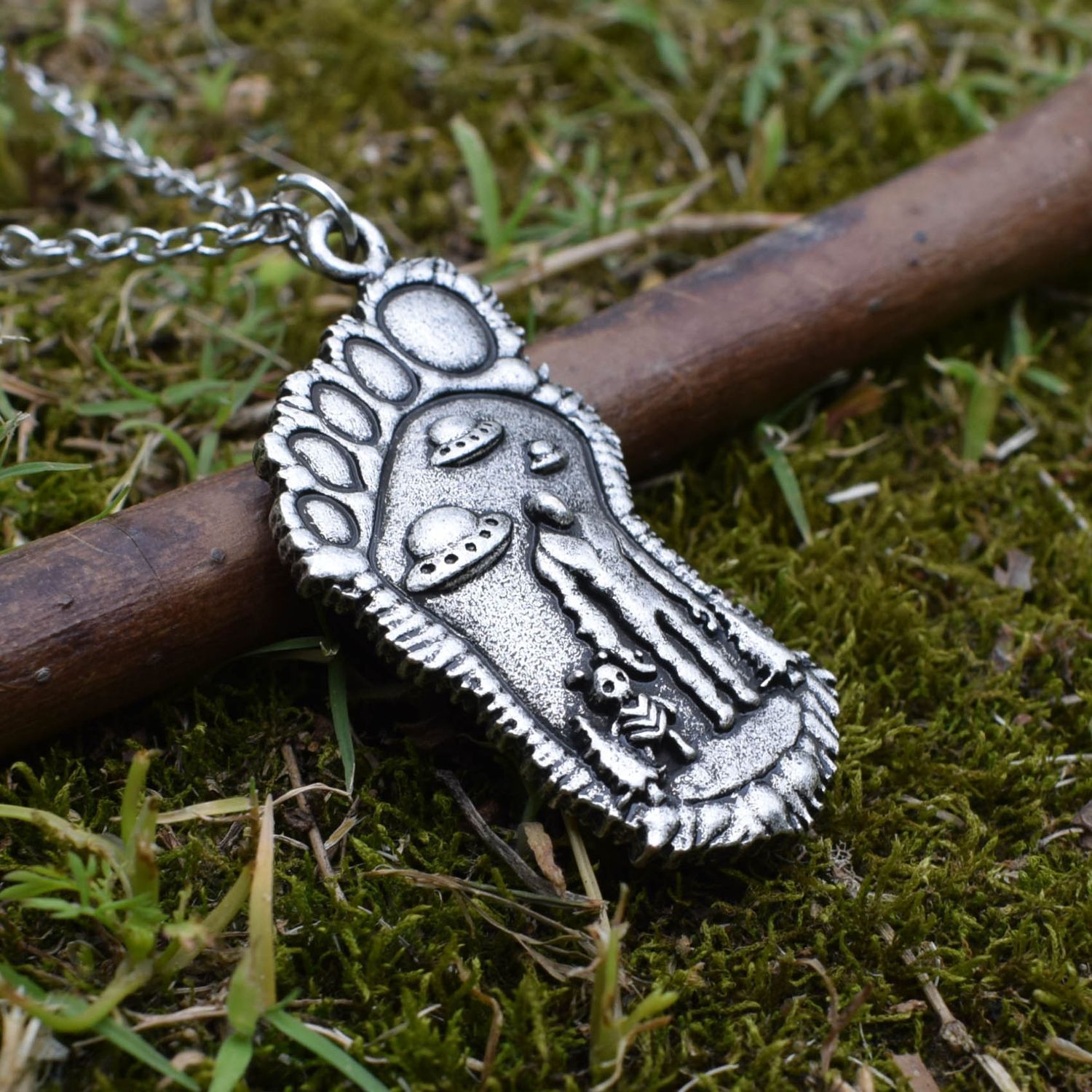 Silver Bigfoot Necklace with Alien Buddy Pendant on a branch